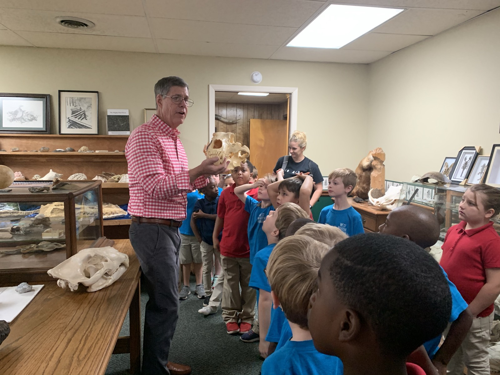 Mickey Webb holding a bear skull up for a class of young students to see