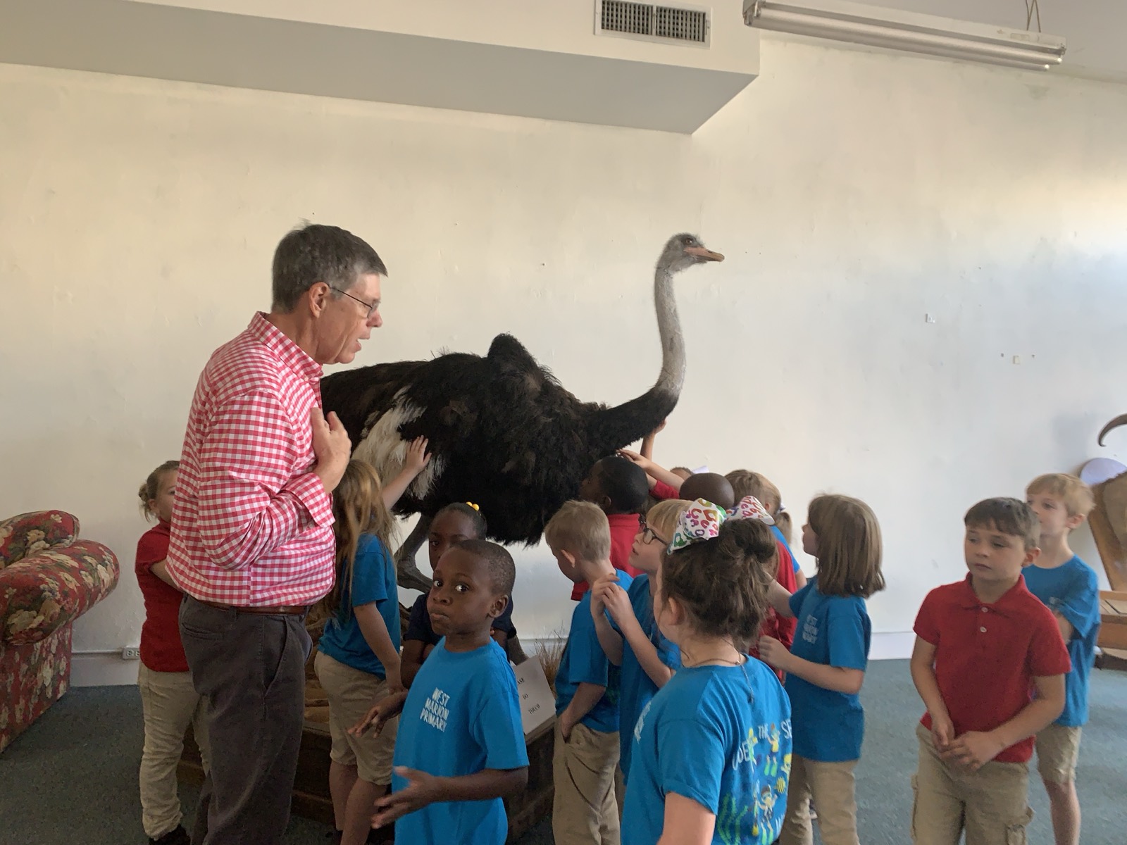 Mickey Webb standing with a class beside the museum's full-sized ostrich mount